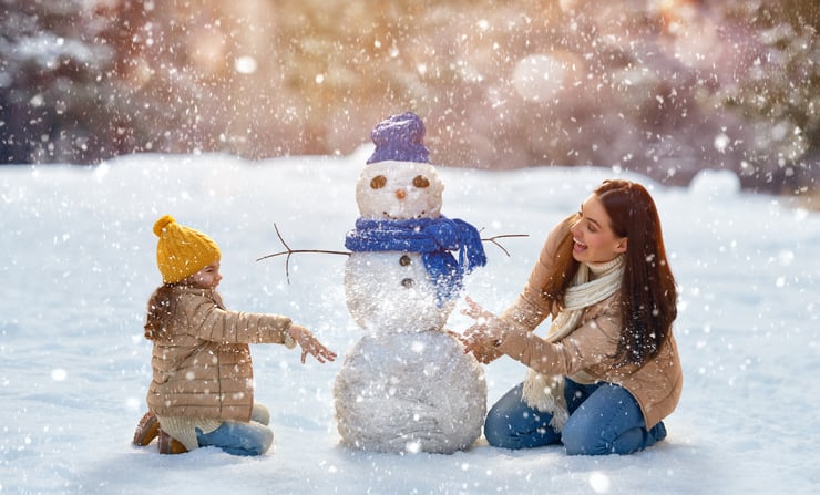 kvinne barn leker snømann vinteraktiviteter made for movement