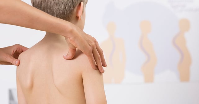 Fysioterapeut som korrigerer barn med feil stilling med hendene