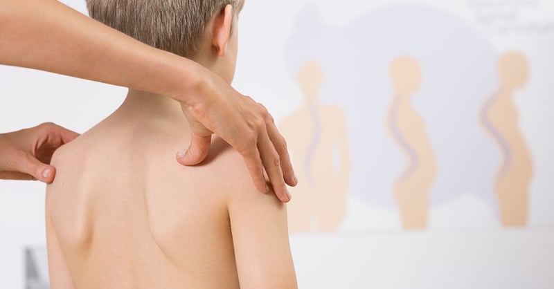 Physiotherapeut korrigiert Fehlhaltungen von Kindern mit ihren Händen