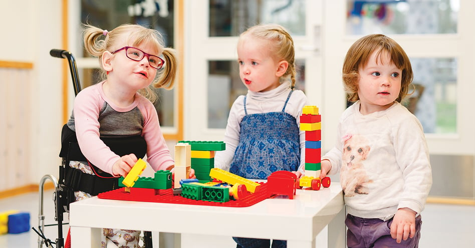 Drei kleine Mädchen, die zusammen mit Lego spielen