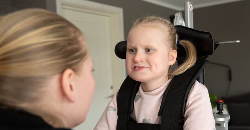 Selma a girl with Rett syndrome in assitive device