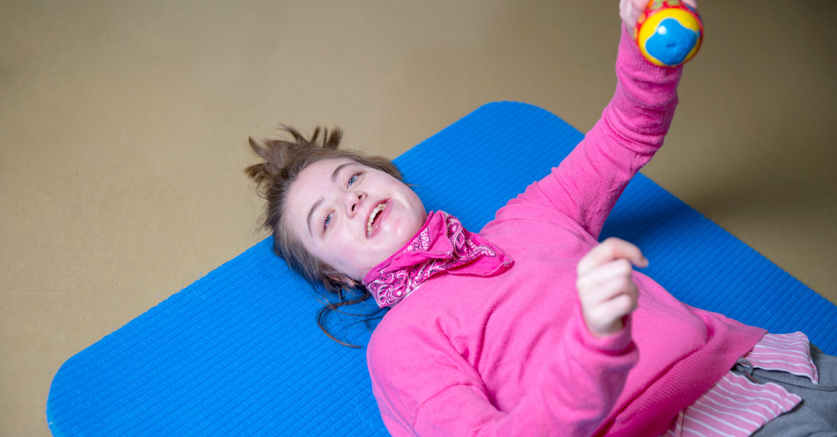 Girl with disabilities lying on the floor smiling