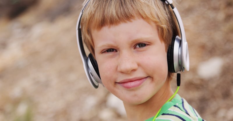 Blonde boy with headphones. Music therapy for kids with disabilities