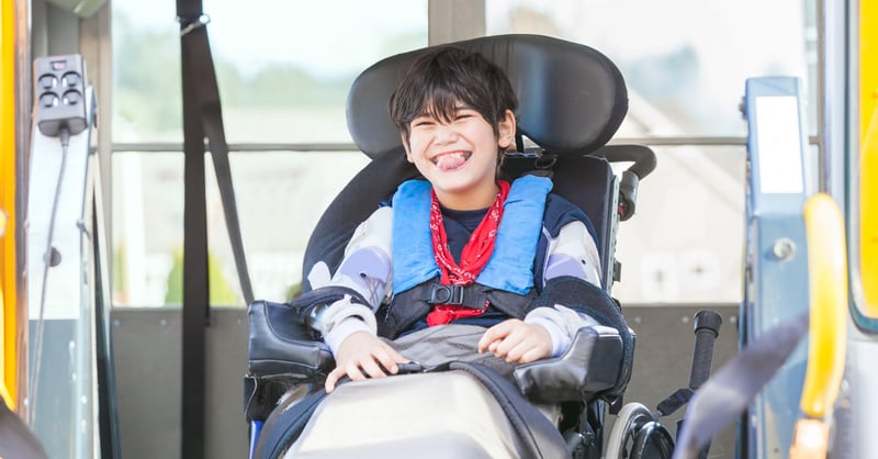 Smiling boy in assistive device. What is gmfcs, and why is it used?
